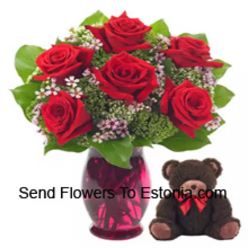 7 Trandafiri roșii cu câteva frunze de ferigă într-un vas de sticlă împreună cu un ursuleț drăguț de 14 inch înălțime