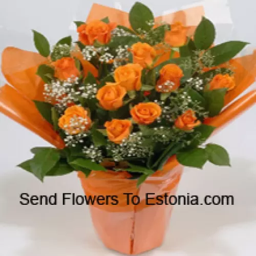 Uma bela disposição de 19 rosas laranja com complementos sazonais