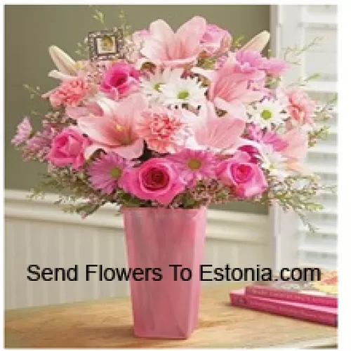 Pinkkejä ruusuja, pinkkejä neilikoita, pinkkejä gerberoita, valkoisia gerberoita ja pinkkejä liljoja sesongin täyteaineiden kanssa lasimaljakossa
