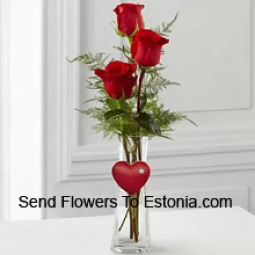 3 красные розы в стеклянной вазе с прикрепленным к ней маленьким сердцем