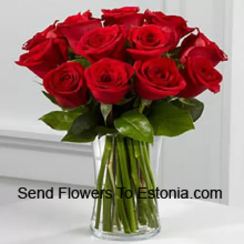 11朵红玫瑰和一些蕨类植物在花瓶中