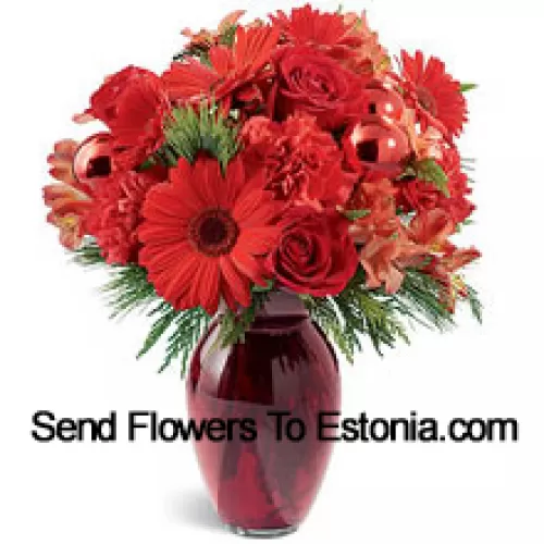 A beautiful holiday red glass vase holds an array of crimson blossoms. Carnations, roses, Gerbera daisies and alstroemeria are decorated with shiny red glass ornaments and interspersed with Christmas greens. Great to give, or to keep for yourself!  (Please Note That We Reserve The Right To Substitute Any Product With A Suitable Product Of Equal Value In Case Of Non-Availability Of A Certain Product)